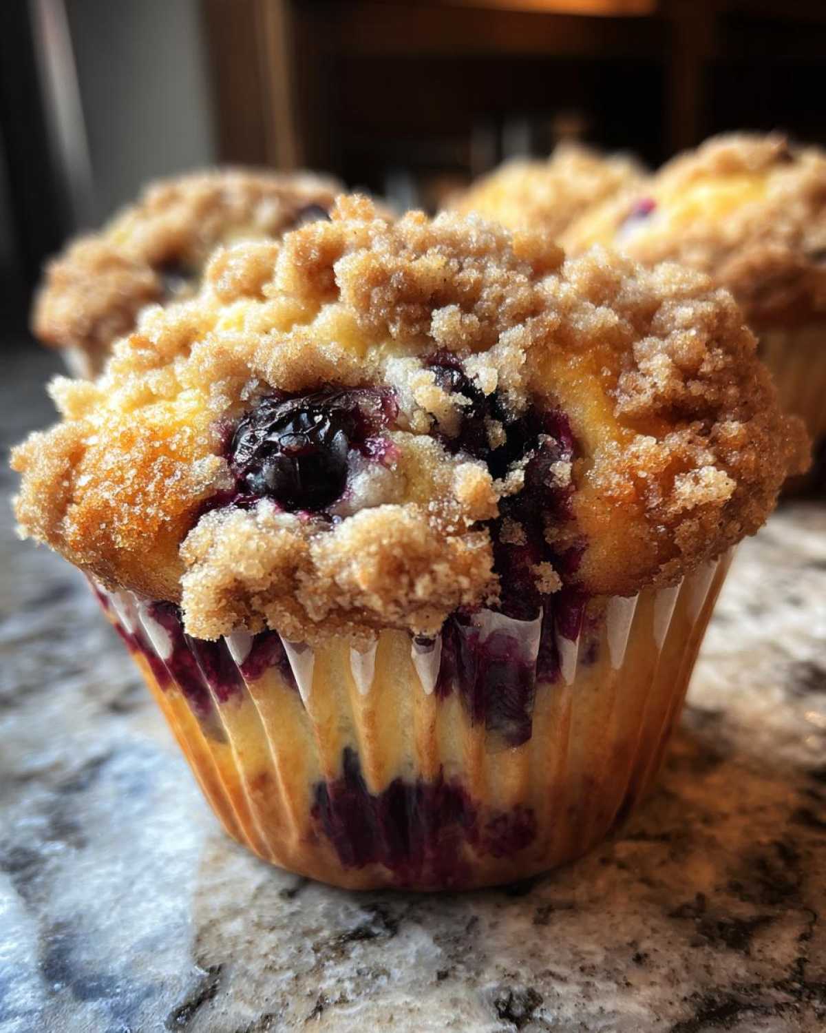 A close-up of a freshly baked blueberry muffin topped with golden brown streusel topping.