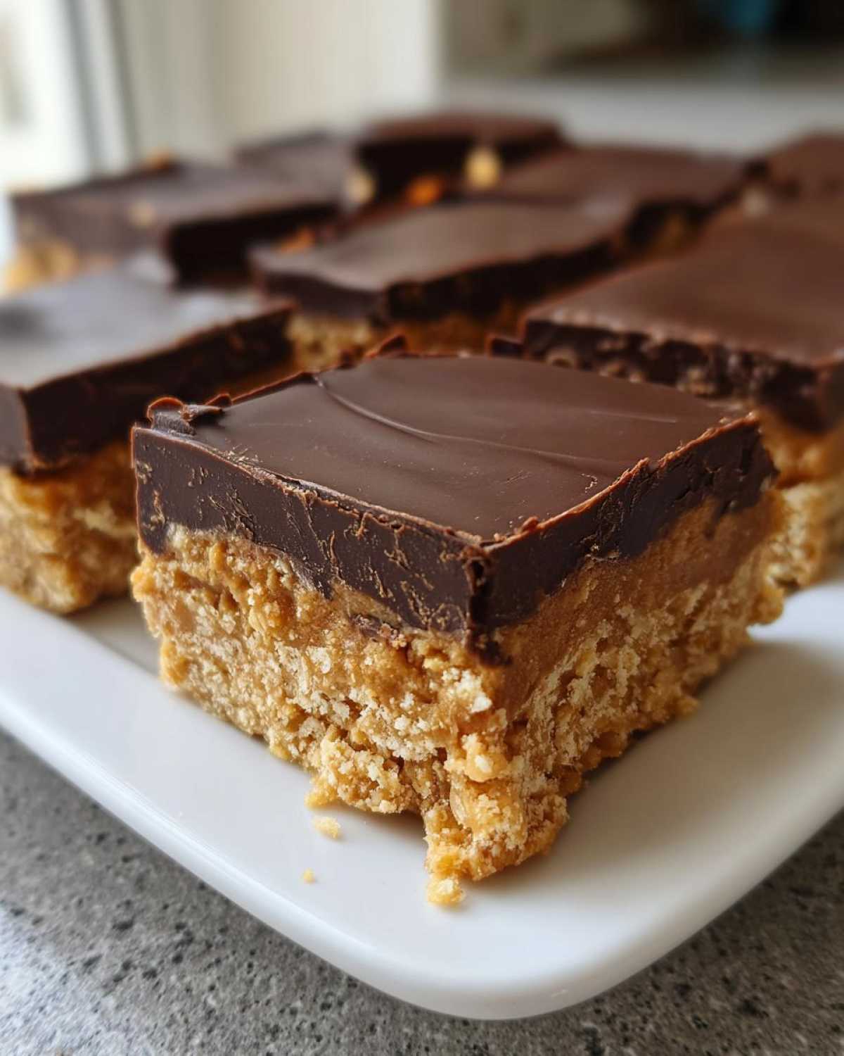 A close-up of a square portion of Buckeye Graham Crackers showing the crumbly peanut butter base and smooth chocolate topping.