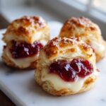 Three golden, flaky puff pastry cranberry brie bites filled with melted brie and rich cranberry sauce.