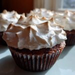 Close-up of a rich chocolate cupcake topped with fluffy, toasted meringue, one of several hot chocolate cupcakes.