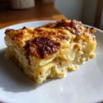 A close-up serving of creamy, layered potatoes au gratin with a deeply browned, cheesy crust.