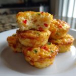 A stack of savory, golden-brown egg bites made with 12 eggs, showing a fluffy interior texture.