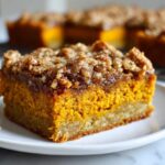 Close-up of a square slice of amazing pumpkin crunch cake with a thick, sugary crumb topping.