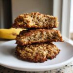 Three banana oatmeal cookies stacked, showing the soft, textured interior full of oats.