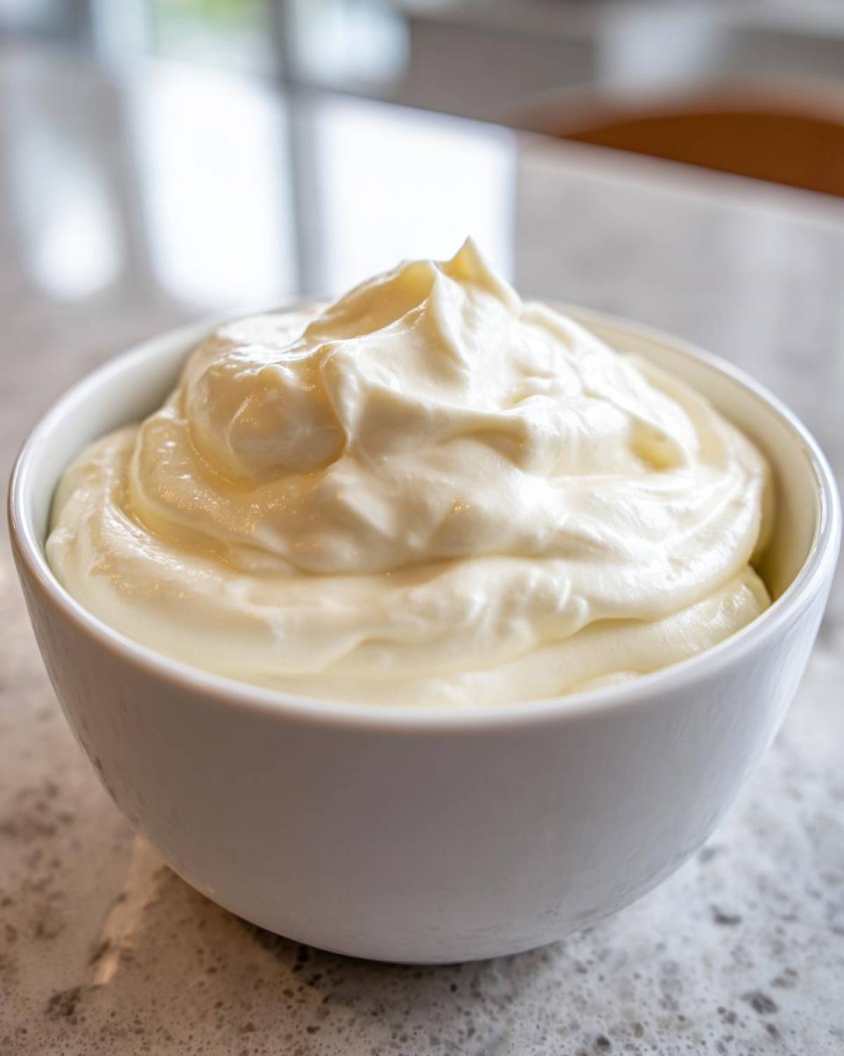 A white bowl filled with a thick, creamy white base mixture for horseradish sauce.