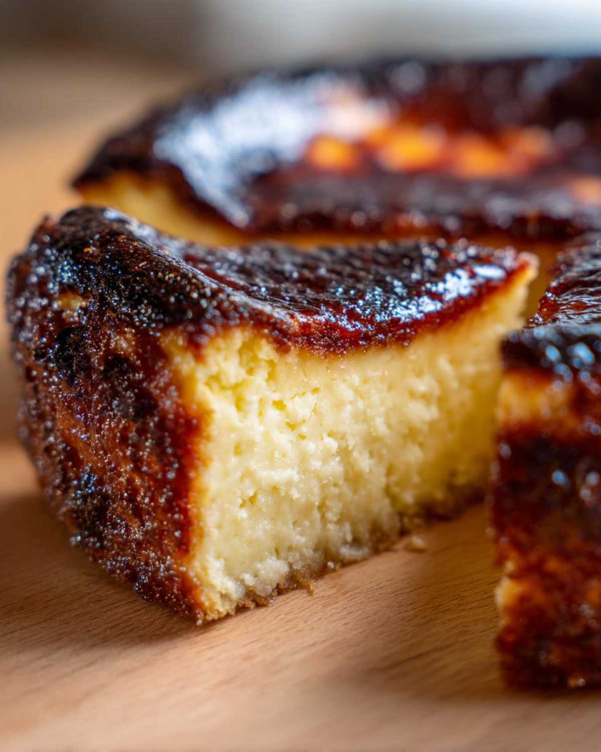 Close-up of a slice of creamy basque cheesecake showing its signature dark, caramelized top.