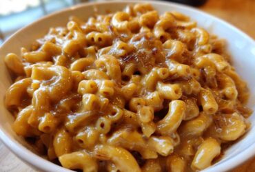 Close-up of creamy french onion pasta made with elbow macaroni and caramelized onions in a white bowl.
