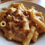 Close-up of creamy french onion pasta featuring rigatoni coated in a rich, cheesy sauce with caramelized onions.
