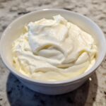 A close-up of thick, creamy homemade horseradish sauce filling a small white bowl.