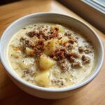 Close-up of a hearty bowl of creamy sausage potato soup topped with crumbled sausage.