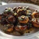 A close-up of savory, browned garlic butter mushrooms garnished with fresh parsley, ready to eat.