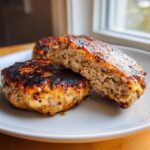 Close-up of two Air Fryer Turkey Burgers, one cut in half showing the juicy interior texture.