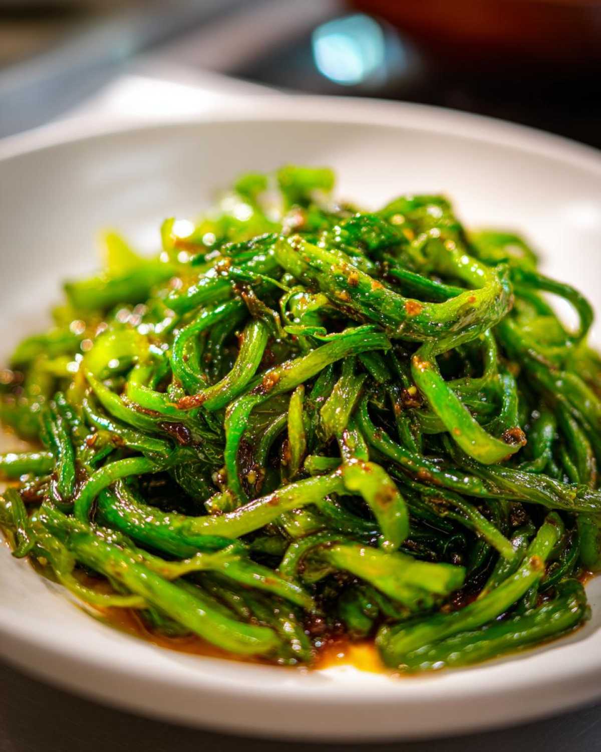 Close-up of vibrant green stir-fried cabbage strips coated in a savory garlic ginger sauce.