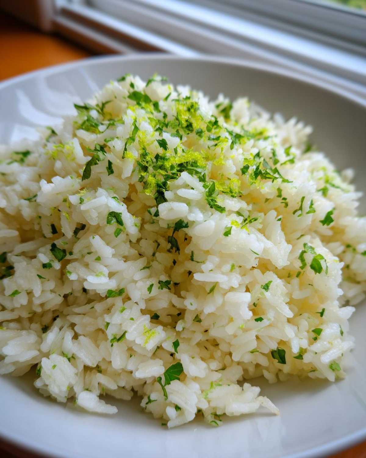 Close-up of fluffy Cilantro Lime Rice topped with bright green lime zest and chopped cilantro.