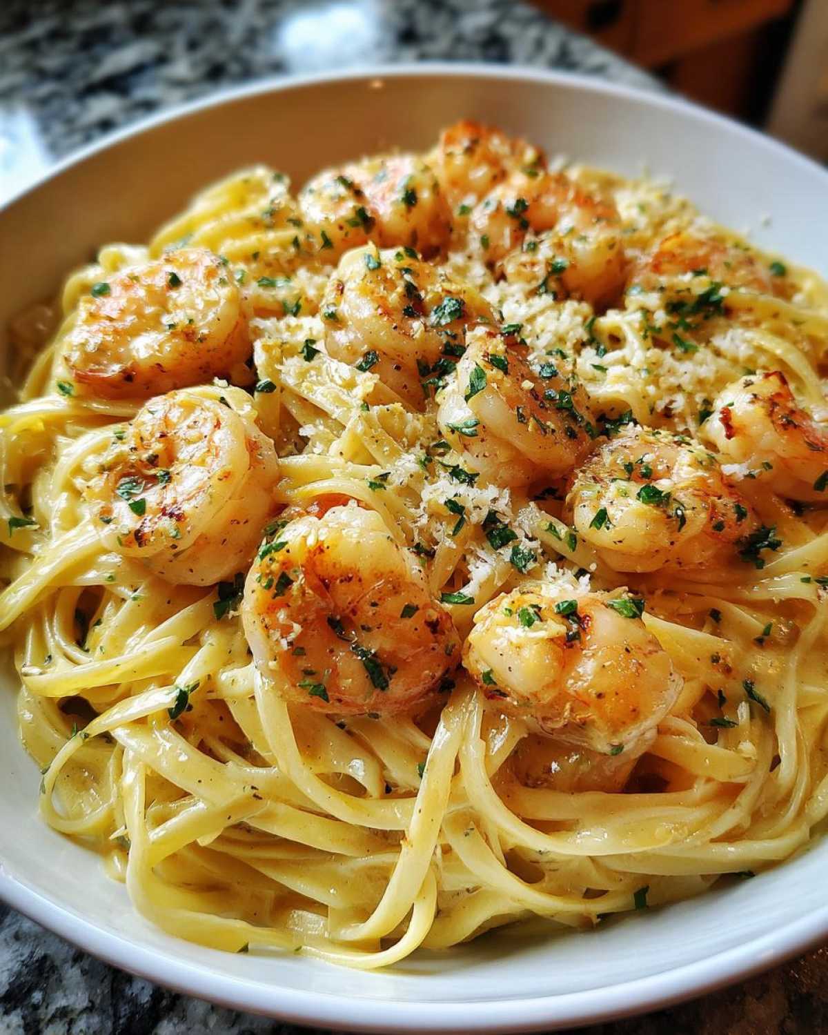 Close-up of Creamy Lemon Garlic Shrimp Pasta topped with parmesan and parsley.