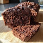 Close-up of thick slices showing the fudgy texture of Vegan Chocolate Banana Bread topped with chocolate chips.