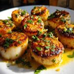 Close-up of seared Garlic Butter Scallops with Lemon, glistening in butter sauce and topped with fresh parsley.