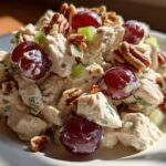 A close-up serving of creamy Honey Mustard Chicken Salad with Grapes, pecans, and celery chunks.