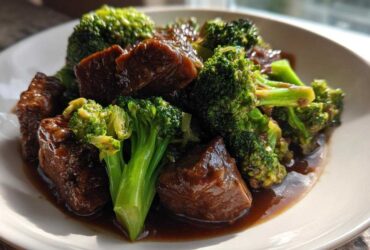 Close-up of tender chunks of beef coated in dark sauce served with bright green broccoli florets in Instant Pot Beef and Broccoli.