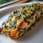 Close-up of a perfectly cooked Keto Garlic Butter Salmon fillet topped with melted butter and fresh parsley.