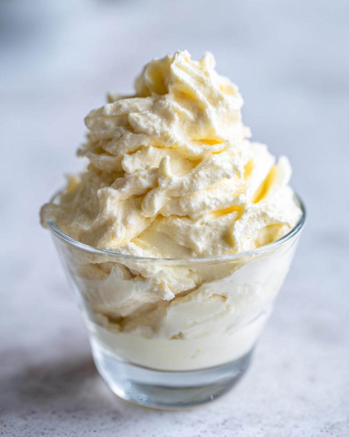 Close-up of fluffy Keto Lemon Cheesecake Mousse piped high in a small clear glass.
