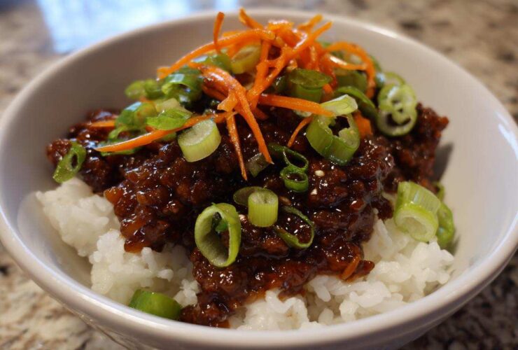 Close-up of Korean Ground Beef Bulgogi Bowls featuring savory ground beef over white rice, topped with shredded carrots and green onions.