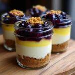 Close-up of layered Lemon Blueberry Cheesecake Jars featuring a graham cracker crust, cream cheese, lemon curd, and blueberry topping.