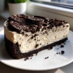 A perfect slice of No-Bake Oreo Cheesecake featuring a dark crust, creamy filling, and Oreo cookie topping.