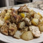 Close-up of seasoned Sheet Pan Lemon Pepper Chicken and Potatoes served on a white plate.