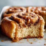 Close-up of a soft Gluten-Free Cinnamon Rolls slice covered in gooey caramel sauce.