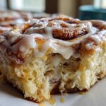Close-up of a soft, fluffy Gluten-Free Cinnamon Roll dripping with white icing.