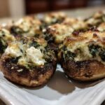 Close-up of baked Spinach and Feta Stuffed Mushrooms with a golden-brown, cheesy top.