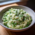 Close-up of creamy Spring Pea and Mint Risotto topped with grated cheese and fresh mint.