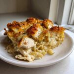 A serving of Cheesy Baked Chicken Alfredo with Crispy Top, featuring creamy pasta, chunks of chicken, and a golden, crunchy topping.