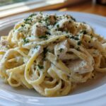 Close-up of a generous serving of Creamy Alfredo Pasta with Chicken and Cheese, topped with fresh parsley.