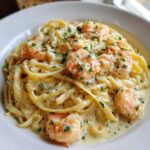 Close-up of Creamy Lemon Garlic Shrimp Pasta featuring fettuccine noodles coated in a rich sauce and topped with plump shrimp and parsley.