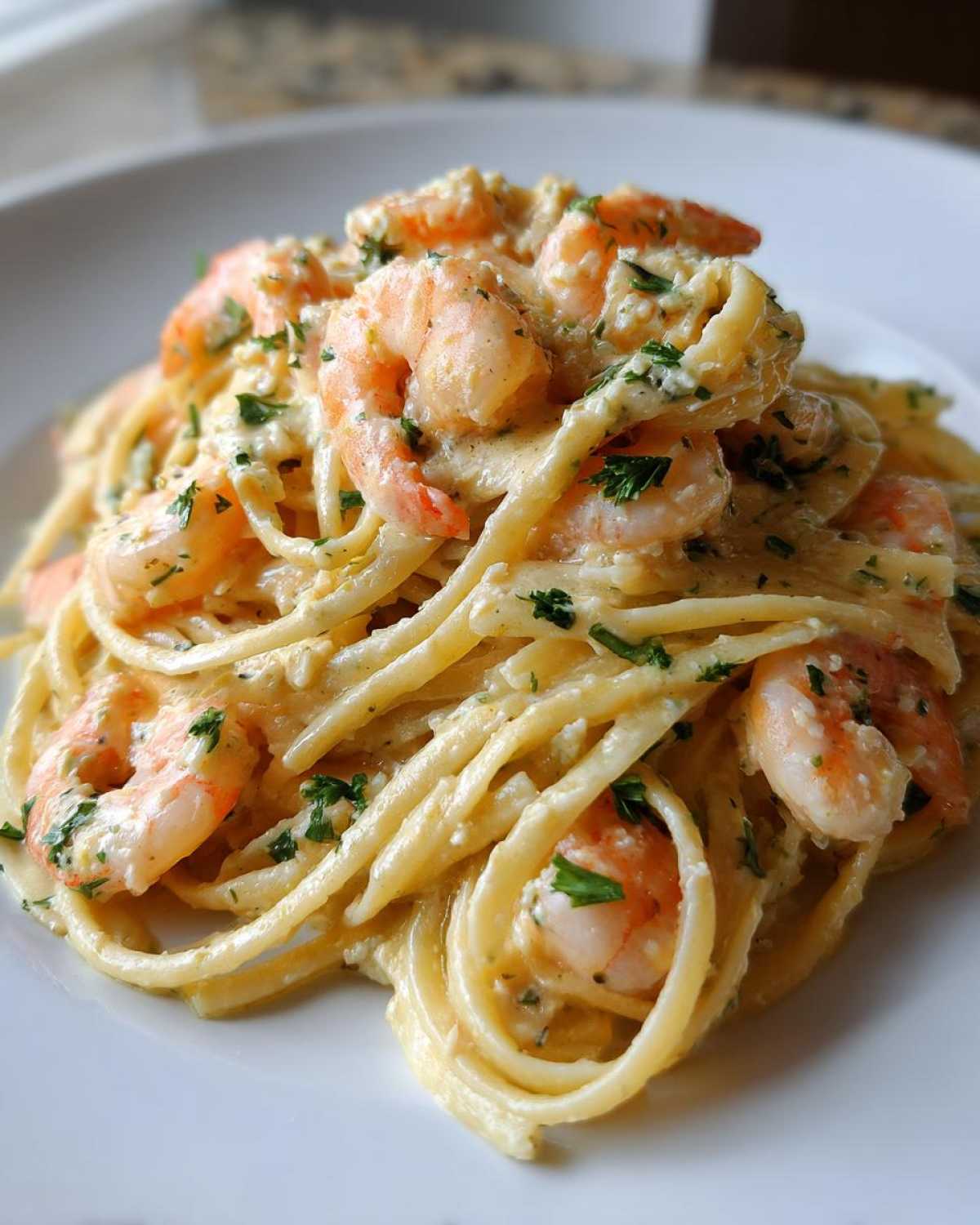 Close-up of a serving of Creamy Lemon Garlic Shrimp Pasta tossed in a rich sauce and garnished with parsley.
