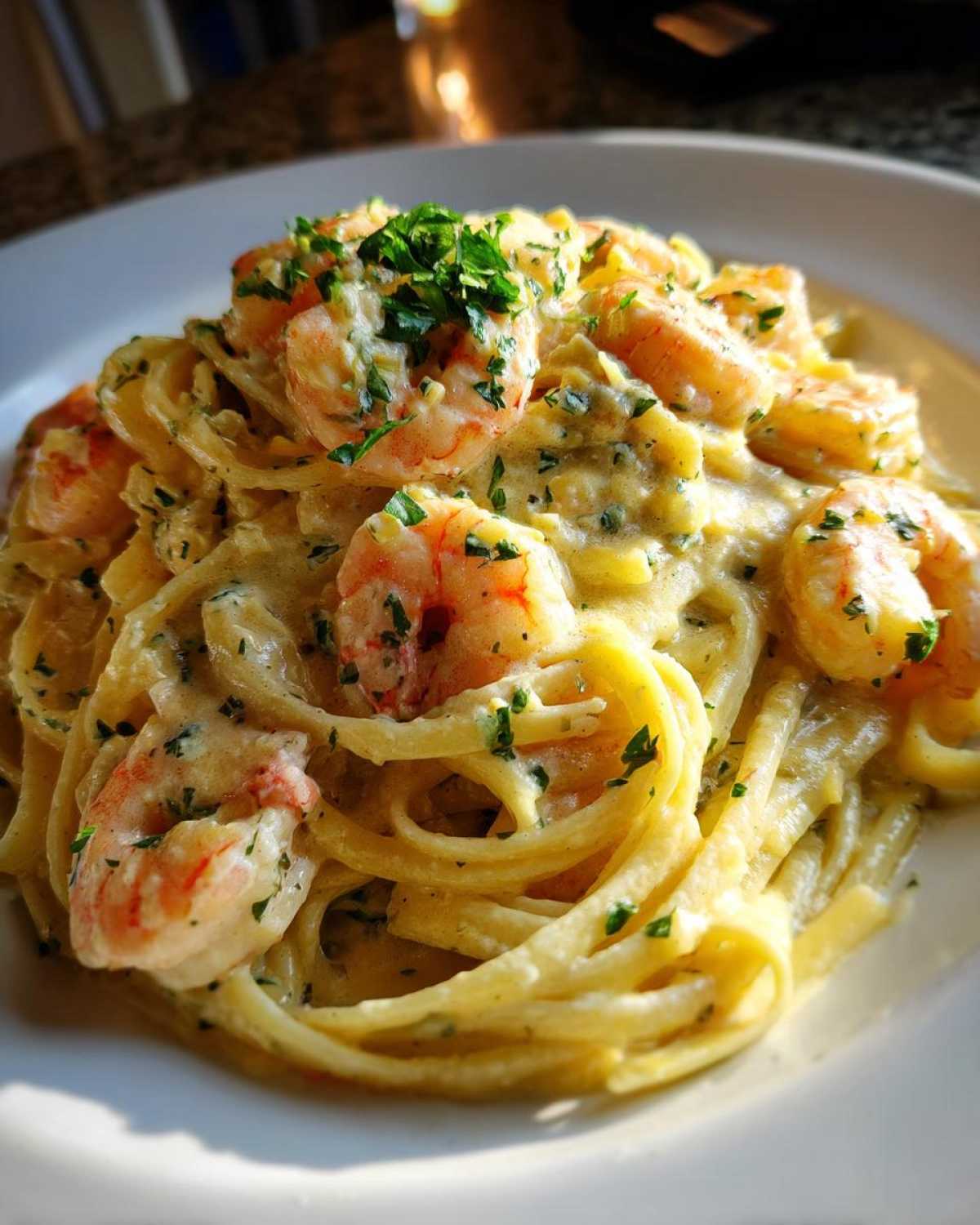 Close-up of rich Creamy Lemon Garlic Shrimp Pasta tossed in a white sauce and topped with fresh parsley.