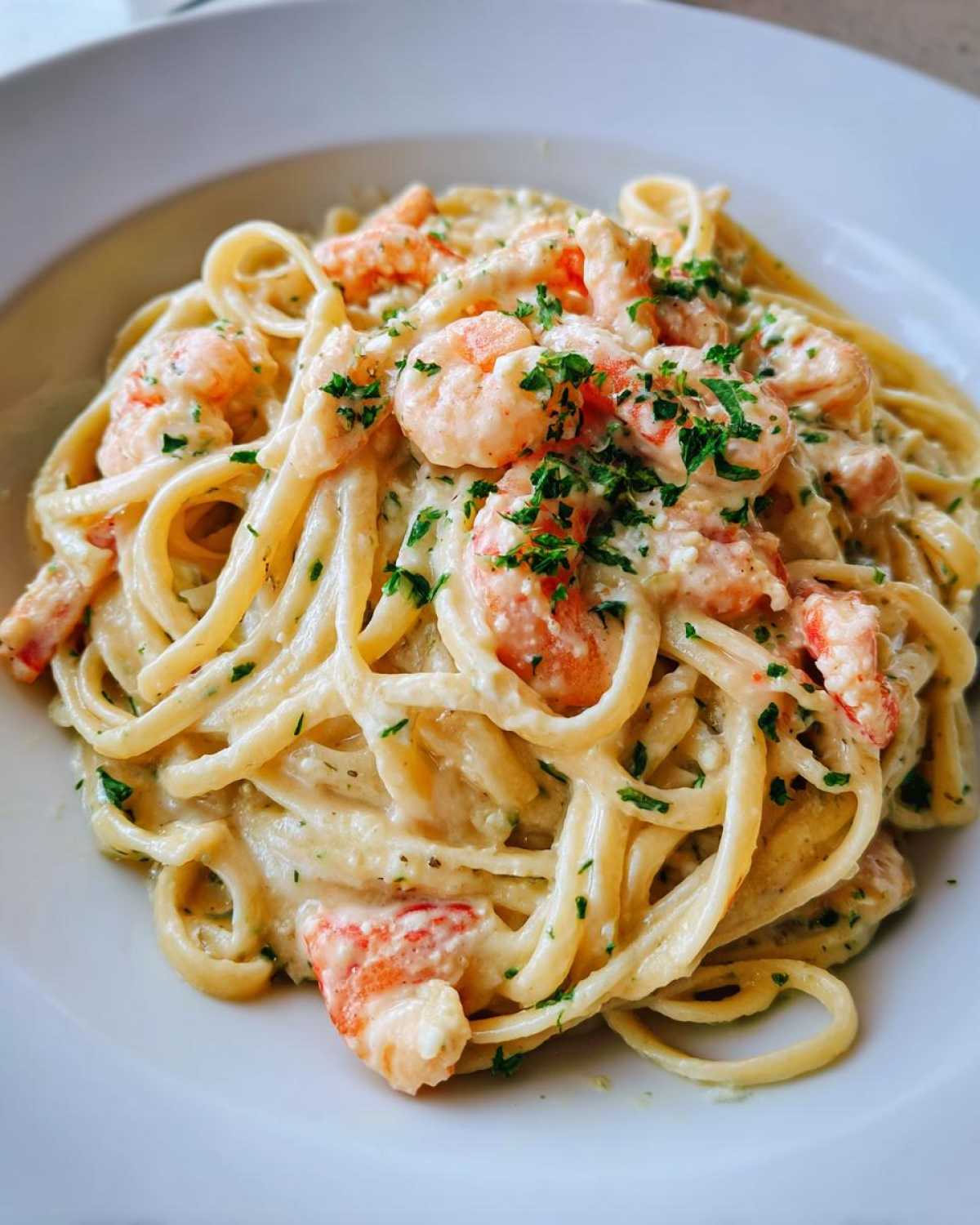 Close-up of a bowl of Creamy Lemon Garlic Shrimp Pasta garnished with fresh parsley.