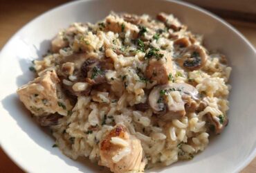 Close-up of a bowl filled with Creamy Mushroom Chicken and Rice Skillet, topped with parsley.