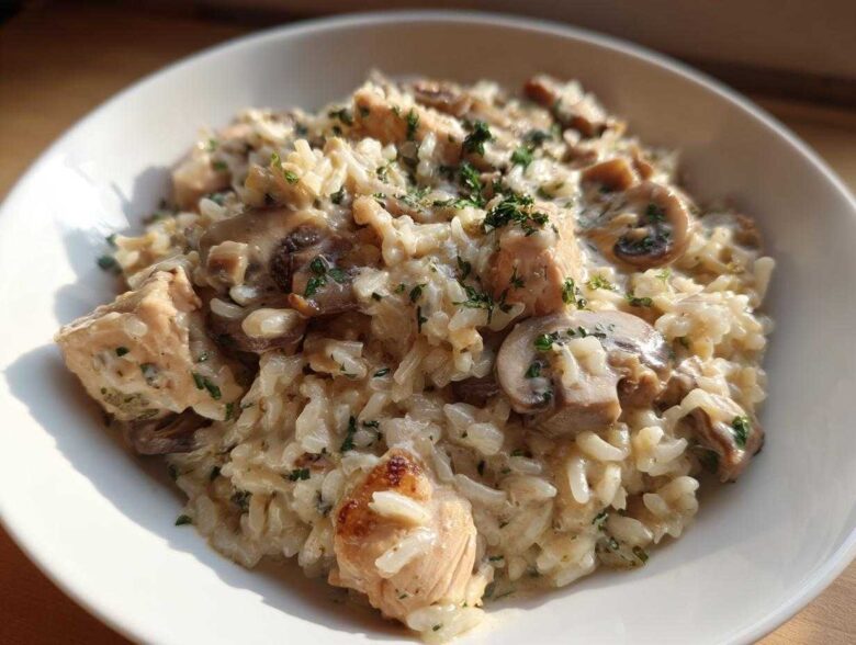 Close-up of a bowl filled with Creamy Mushroom Chicken and Rice Skillet, topped with parsley.