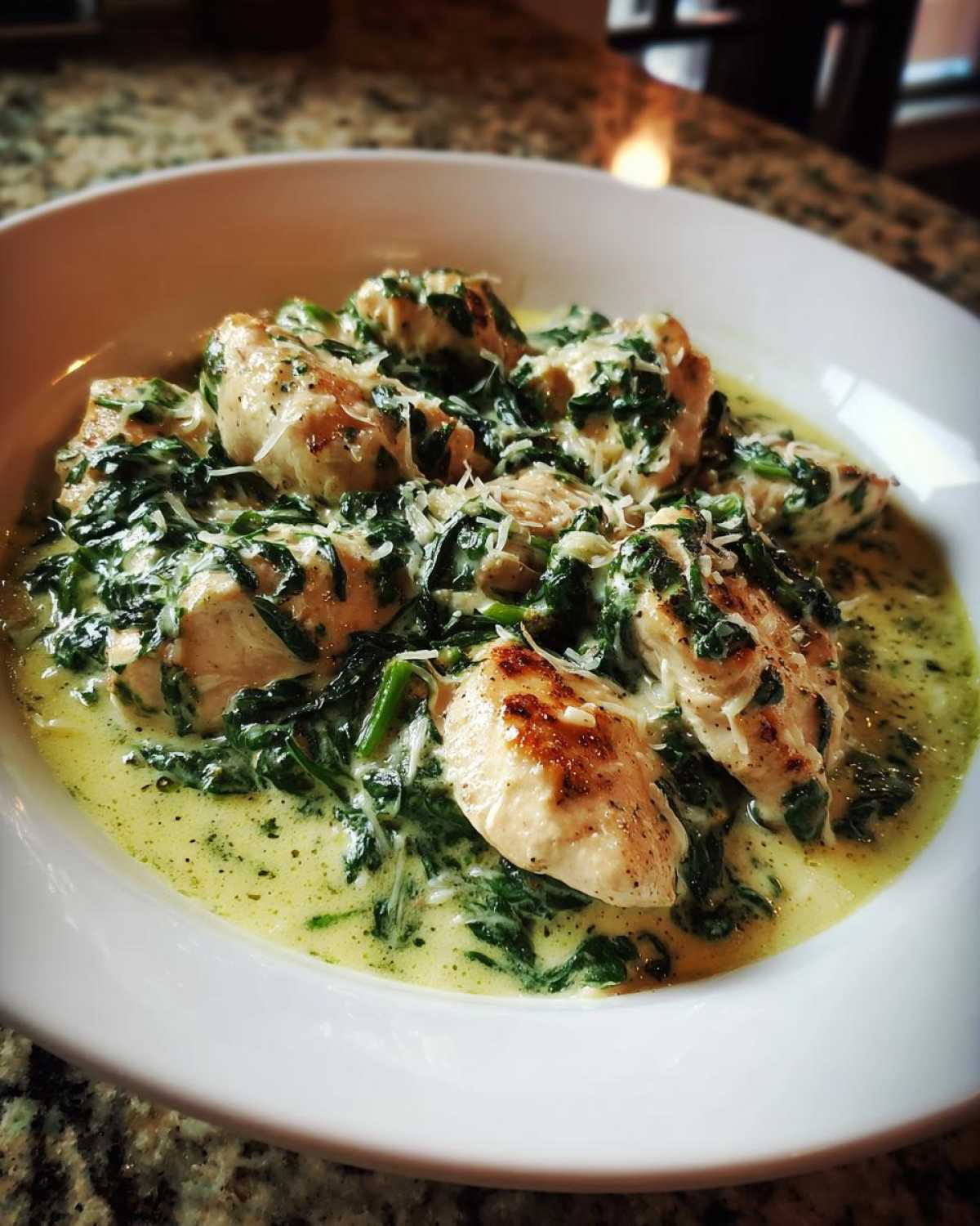 Golden seared chicken pieces covered in a rich, creamy spinach sauce and topped with grated Parmesan cheese for Creamy Spinach Chicken Skillet.