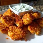 A plate of golden brown Crispy Chicken Nuggets served with a small bowl of creamy Ranch Dip.