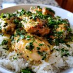 Close-up of Garlic Butter Chicken and Rice One Pot Dinner, featuring browned chicken pieces smothered in garlic butter sauce and fresh parsley over white rice.