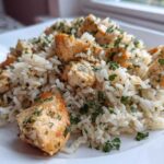 Close-up of Garlic Butter Rice with Chicken Skillet, featuring seasoned white rice mixed with golden chicken pieces and fresh parsley.