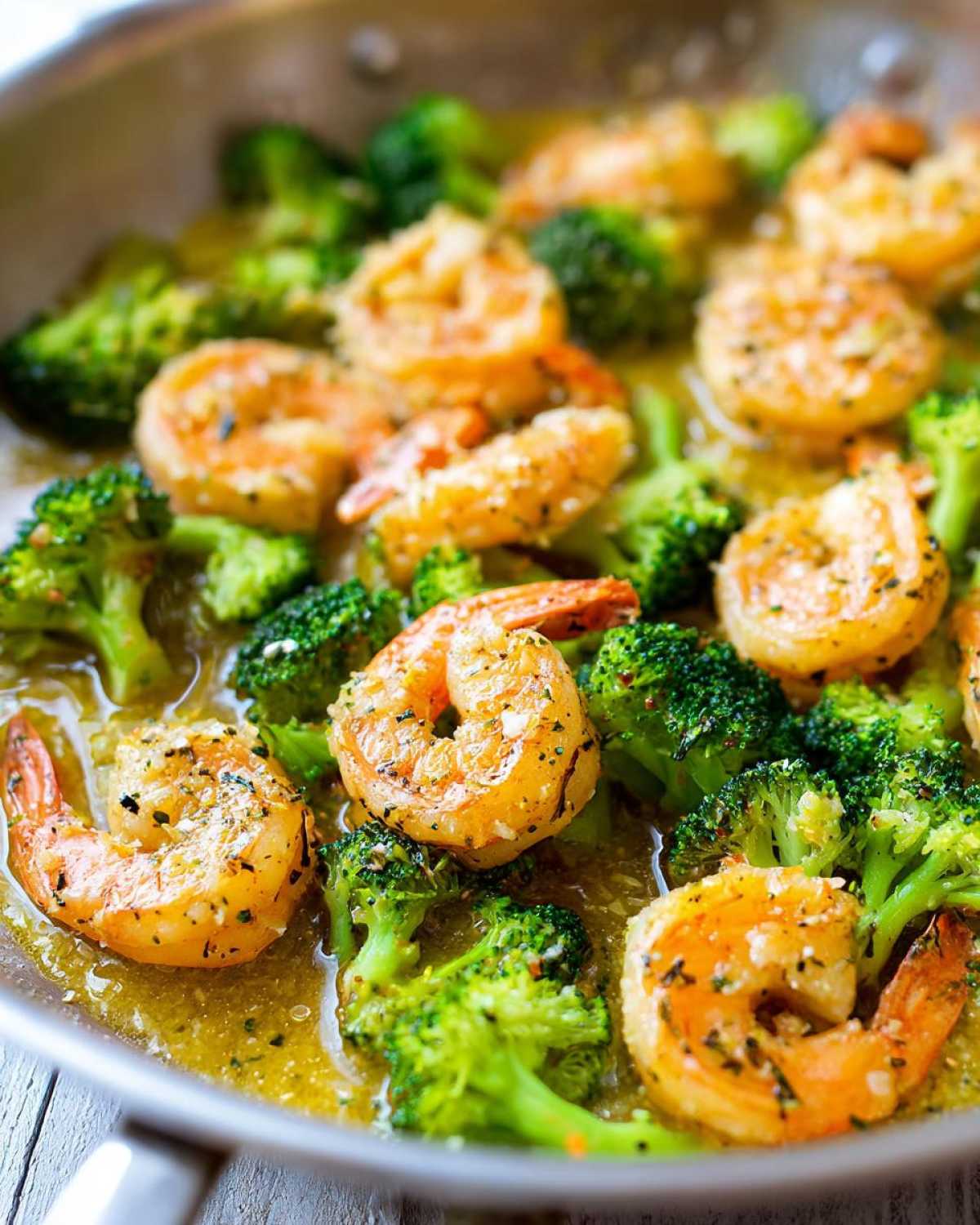 Close-up of shrimp and broccoli cooking in a skillet with rich garlic butter sauce, featuring the Garlic Butter Shrimp and Broccoli Skillet.