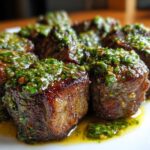 Close-up of perfectly seared Garlic Butter Steak Bites generously topped with a vibrant green herb sauce.