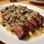 Slices of perfectly cooked steak covered in a rich, creamy mushroom sauce, highlighting the Garlic Butter Steak.