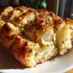 Close-up of golden brown Garlic Parmesan Pull-Apart Bread, showing soft interior pieces dusted with herbs.