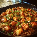 Close-up of Honey Garlic Chicken Skillet with Rice, featuring glazed chicken pieces and green onions.
